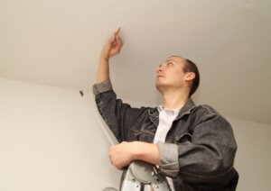 AC engineer measuring the height of the wall